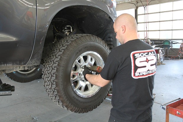 SoCal SuperTrucks Ryan Poe helped us install the Tundra Body Mount plates. Poe has worked with So Cal Super Trucks for seven years and has performed numerous body plate modifications on Toyotas and other vehicles at the shop. To get started, he pulled the wheels off the Tundra.