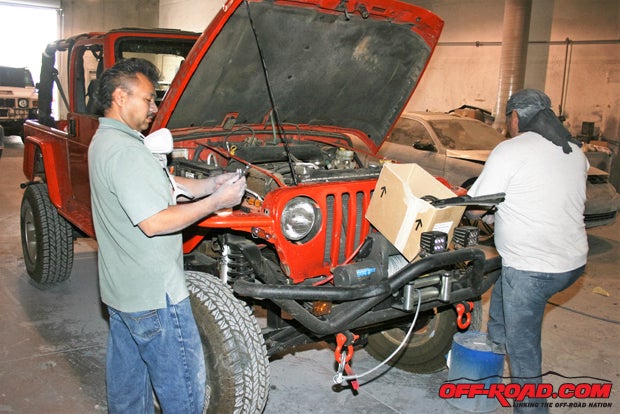 A crew jumps in as soon as the Jeep is stopped and begins to get the Jeep ready for sandingboth hand and machine sanding.